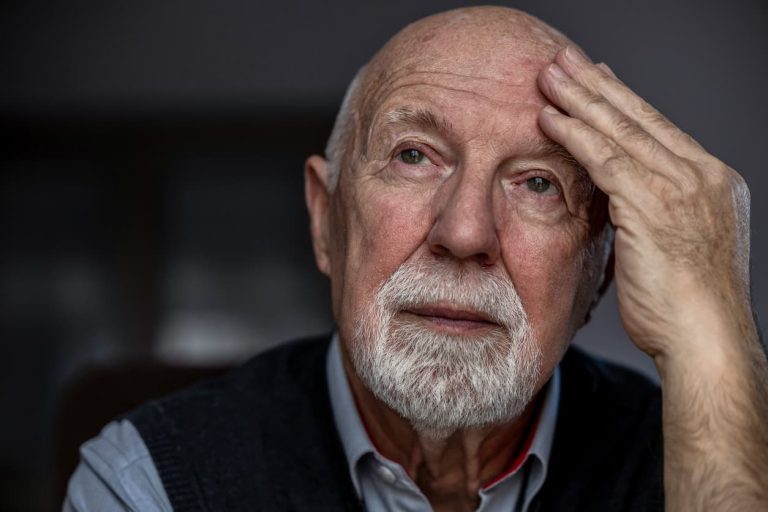 Aging adult rubbing head trying to remember something