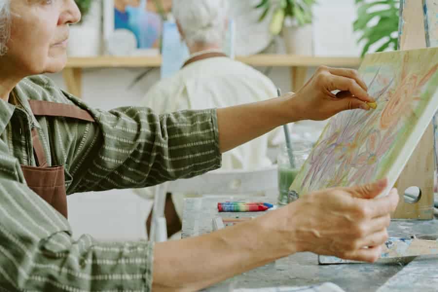 Senior resident making art with pastel chalk