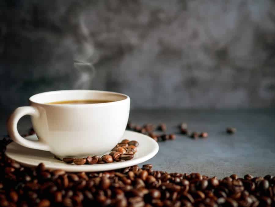 Coffee cup and coffee beans on gray background